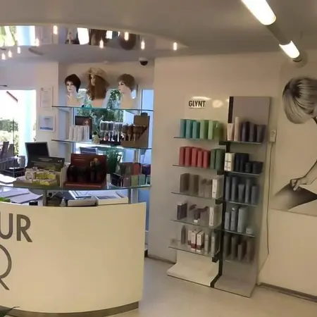 Moderner Friseursalon mit Perücken, Haarpflegeprodukten und stilvollem Empfangsbereich.