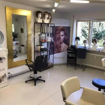 Modernes Friseurstudio mit Perücken, Frisierplatz, großem Spiegel und Haarpflegeprodukten.